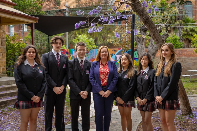 Principal and diverse student leaders standing together in our aboriginal and/or torres strait islander peoples garden setting.